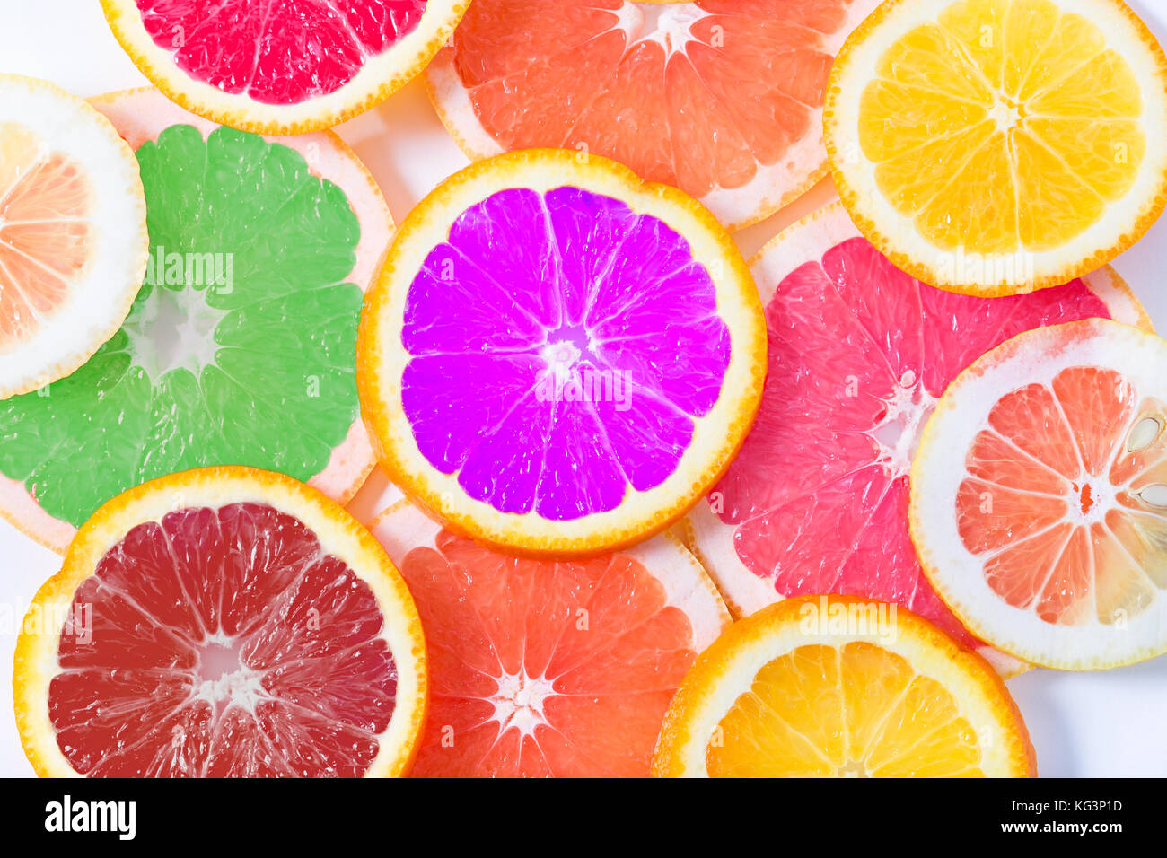 Die mehrfarbige Citrus von künstlichen Farbe durch Kreise schneiden liegt auf einem Tisch. Orange, Zitrone, Grapefruit. Farben nicht üblich für ein Citrus., klein Stockfoto