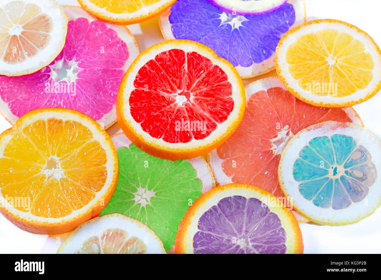 Die mehrfarbige Citrus von künstlichen Farbe durch Kreise schneiden liegt auf einem Tisch. Orange, Zitrone, Grapefruit. Farben nicht üblich für ein Citrus., klein Stockfoto