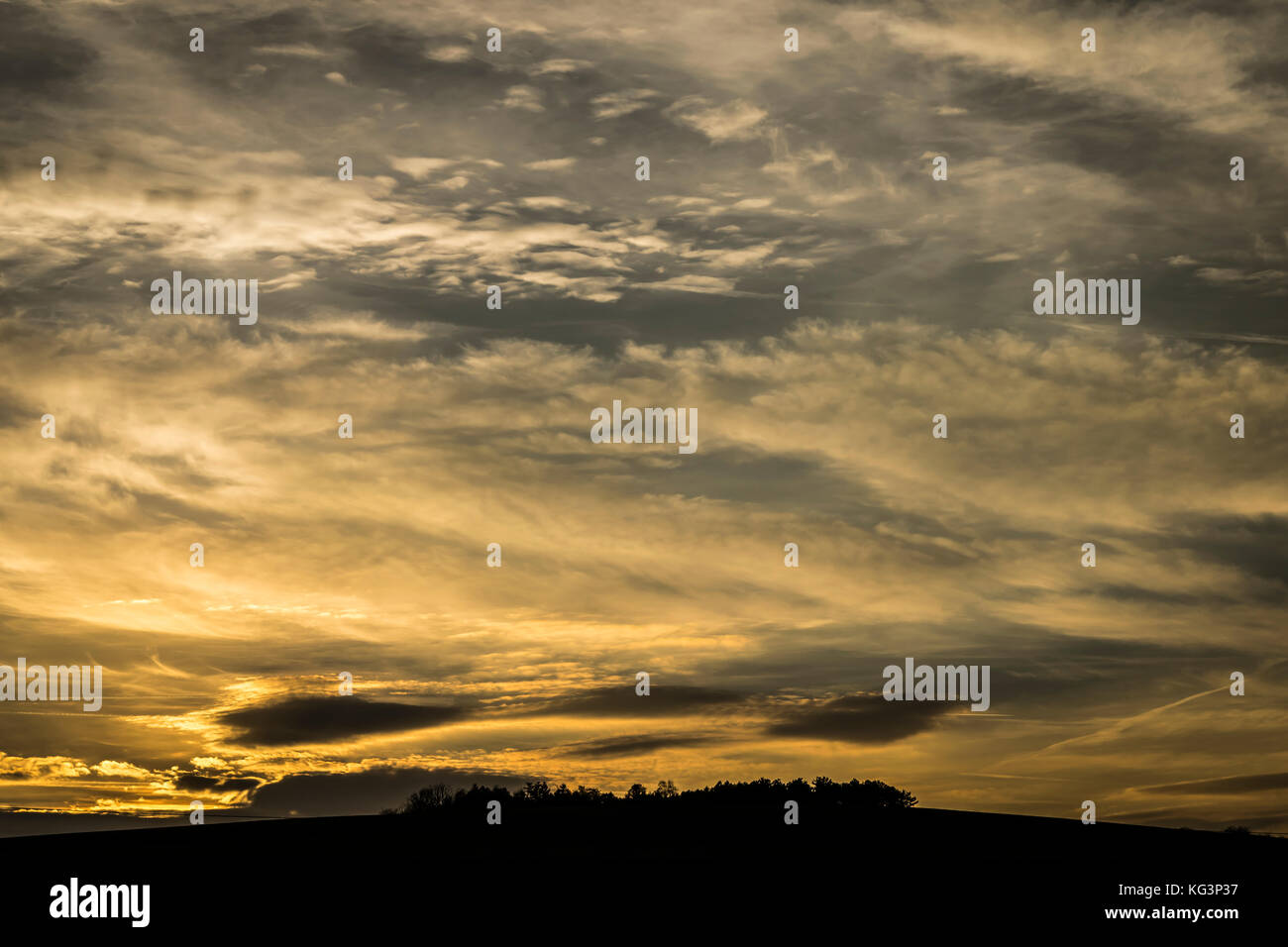 Dramatische Himmel bei Sonnenuntergang. goldenen Licht und schwarze Wolken an stürmischen Wolken über dem Horizont. Stockfoto