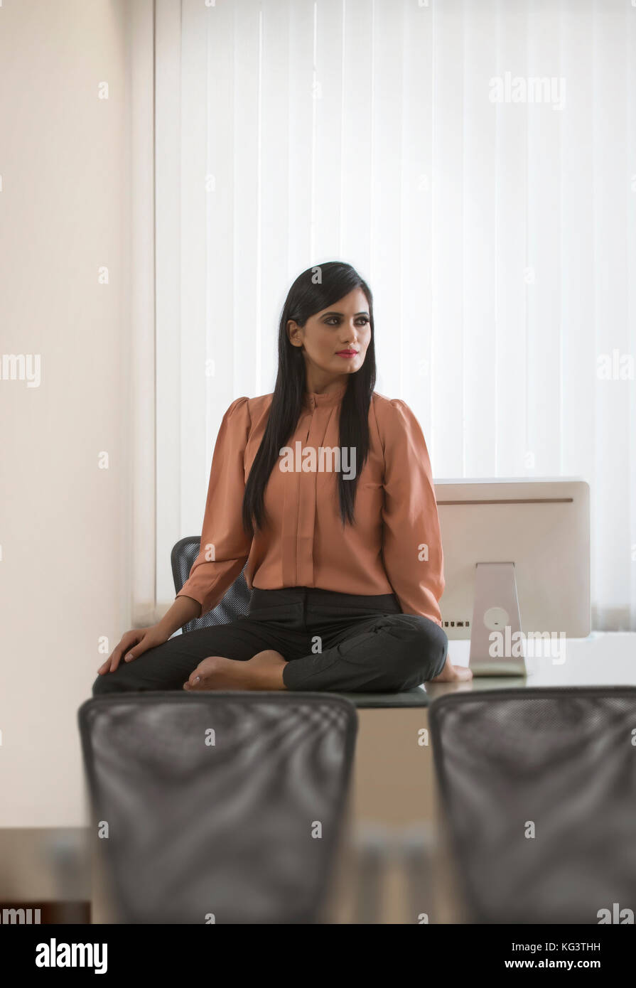 Junge Geschäftsfrau sitzen am Schreibtisch im Büro Stockfoto