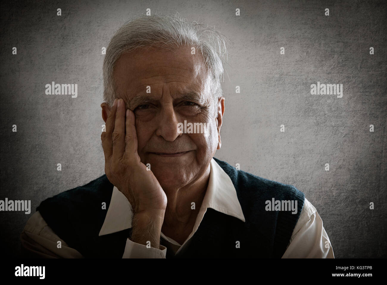 Portrait von lächelnden älteren Mann mit der Hand im Gesicht Stockfoto