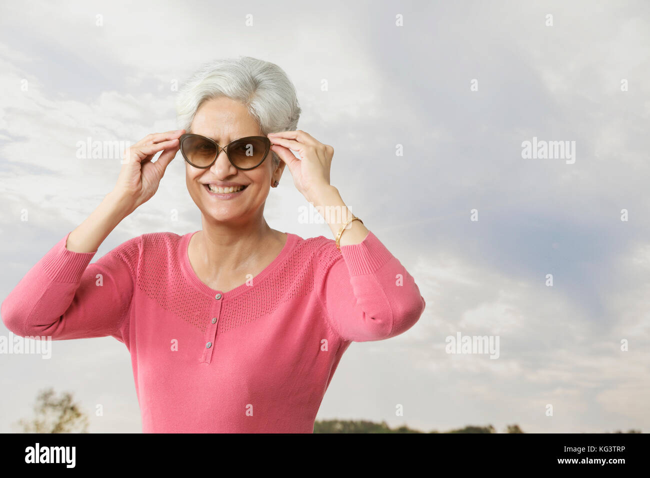 Lächelnde ältere Frau mit Sonnenbrille im Freien Stockfoto