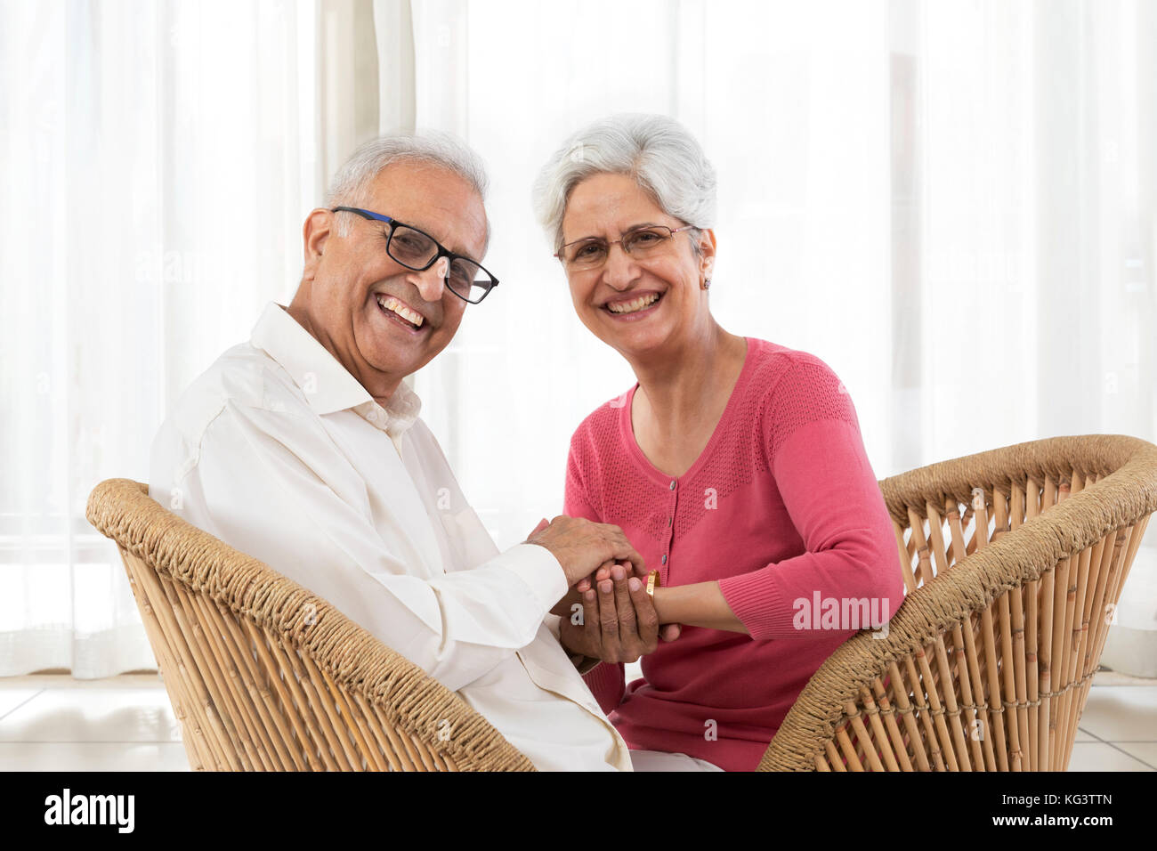 Portrait von Happy senior Paar sitzt auf korbstuhl Stockfoto