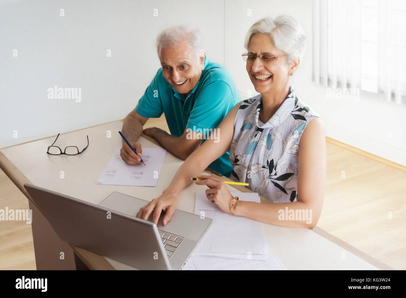 Senior Paar tun Papier arbeiten mit Laptop Stockfoto