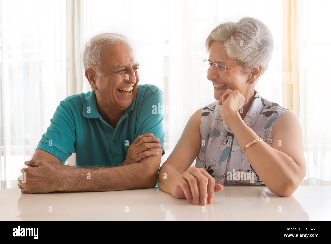Älteres Ehepaar miteinander reden Sitzen am Tisch Stockfoto