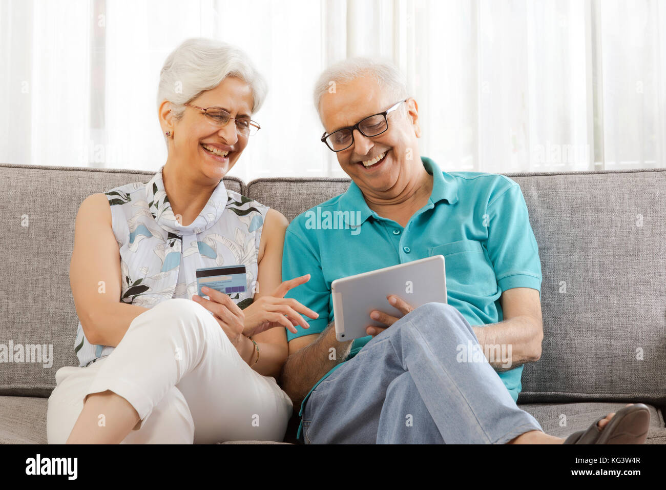 Lächelnd senior Paar Einkaufen online mit Kreditkarte auf digital Tablet Stockfoto