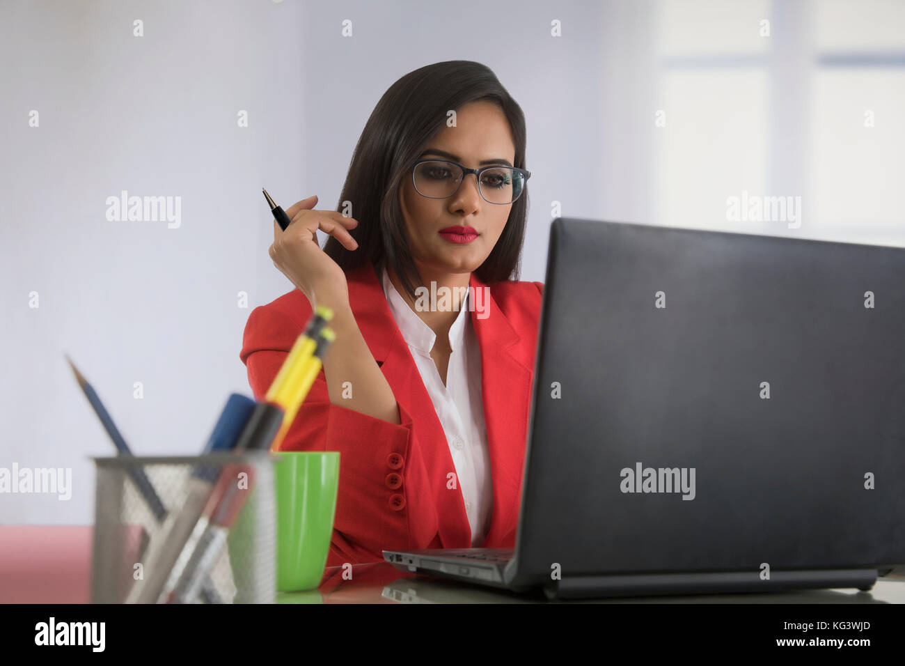 Geschäftsfrau, der die Feder Arbeiten am Notebook am Schreibtisch Stockfoto