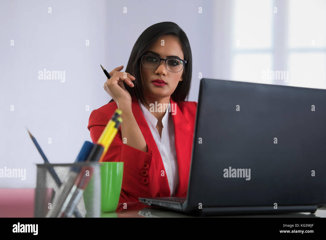 Geschäftsfrau, der die Feder Arbeiten am Notebook am Schreibtisch Stockfoto