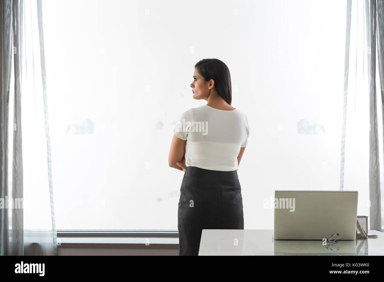 Ansicht der Rückseite des Business Frau, die in der Nähe der Fenster im Büro Stockfoto