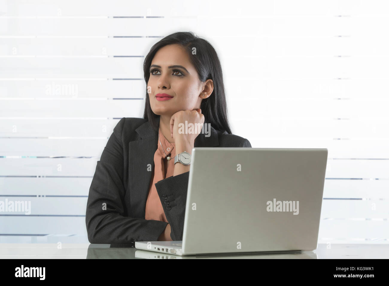 Geschäftsfrau weg schauen sitzt am Schreibtisch im Büro Stockfoto