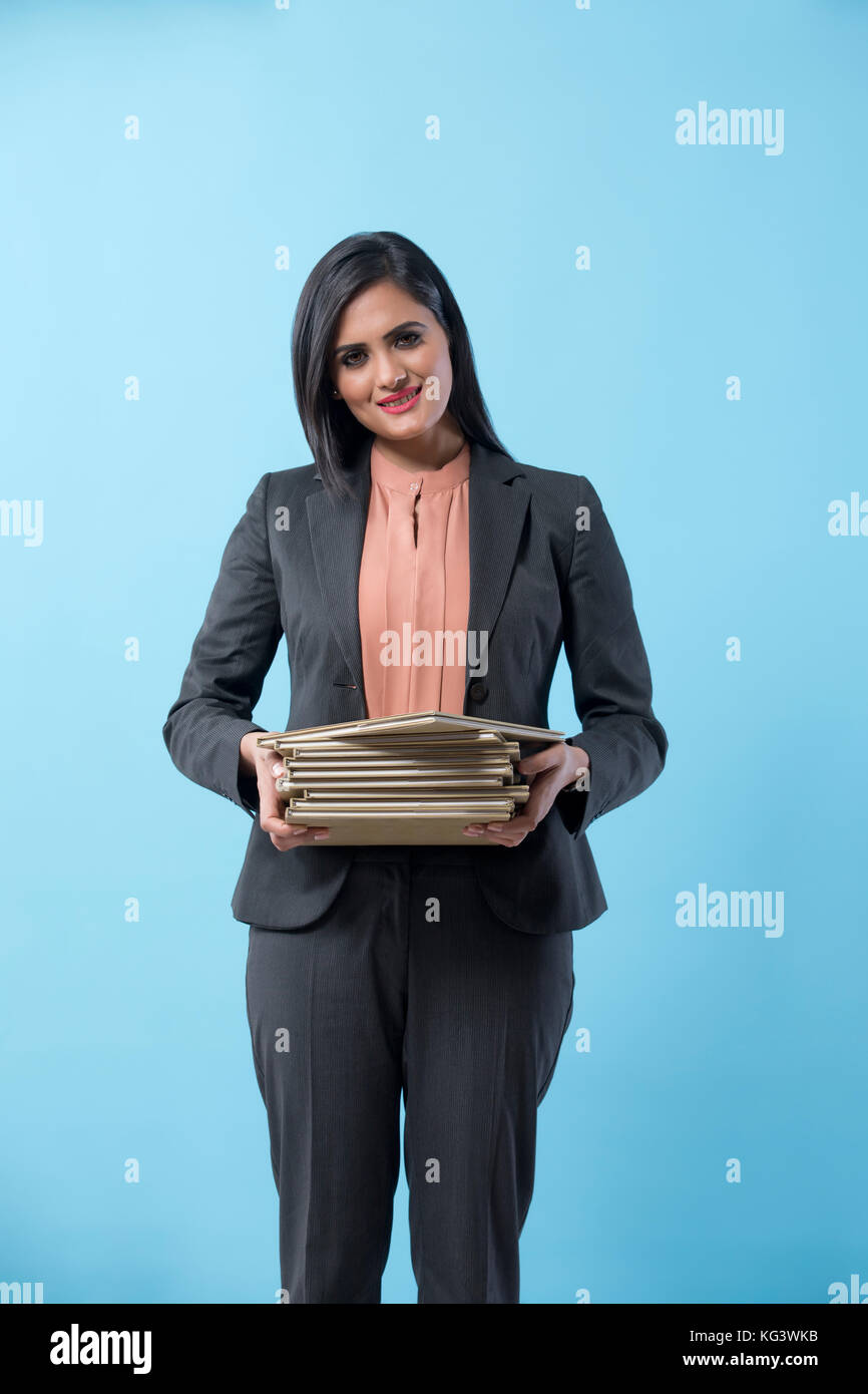 Business woman holding Bücher gegen den blauen Hintergrund Stockfoto