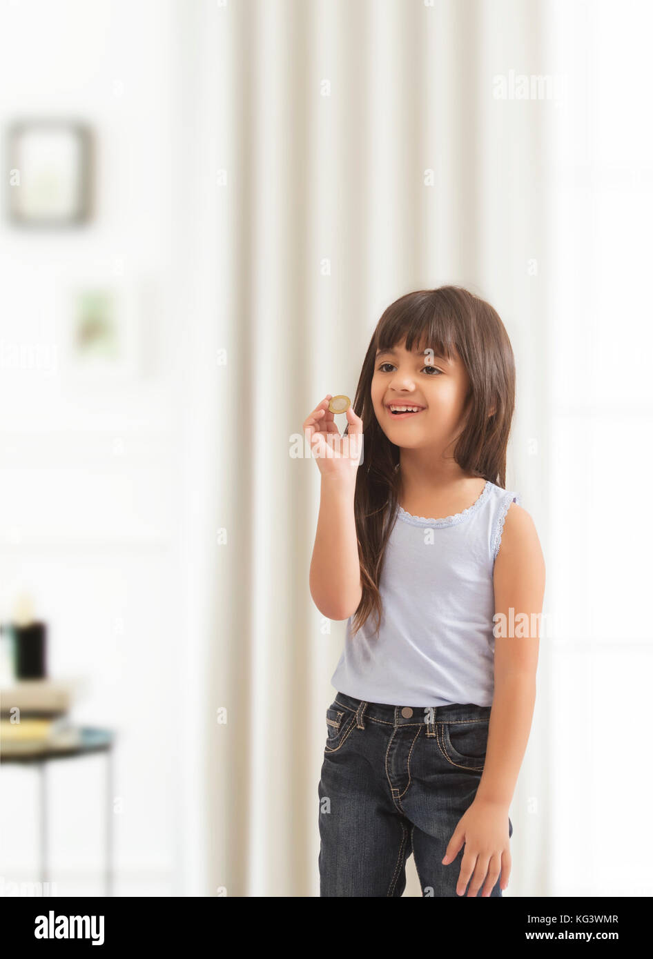 Kleines Mädchen holding Münze Stockfoto