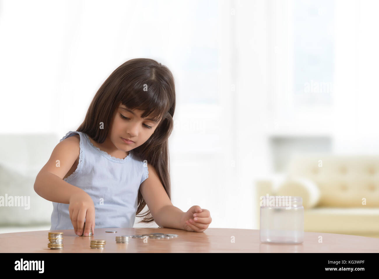 Mädchen, die die Münzen auf den Tisch Stockfoto