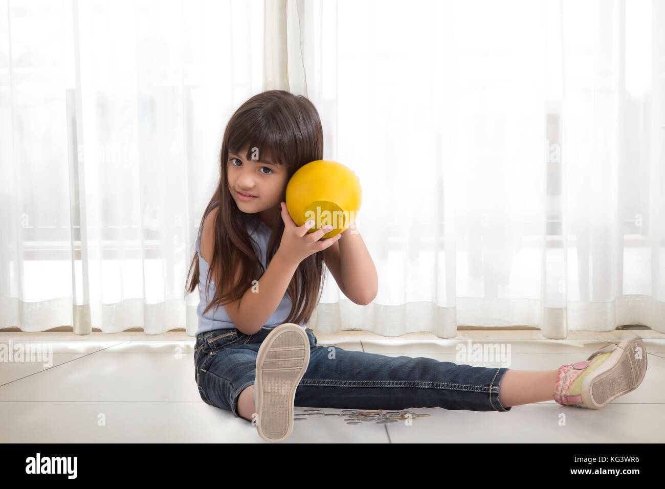 Mädchen schütteln Sparschwein Stockfoto