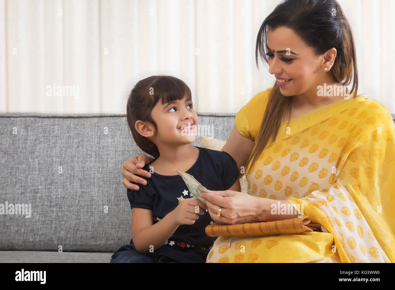 Mutter, Taschengeld zu ihrer Tochter Stockfoto