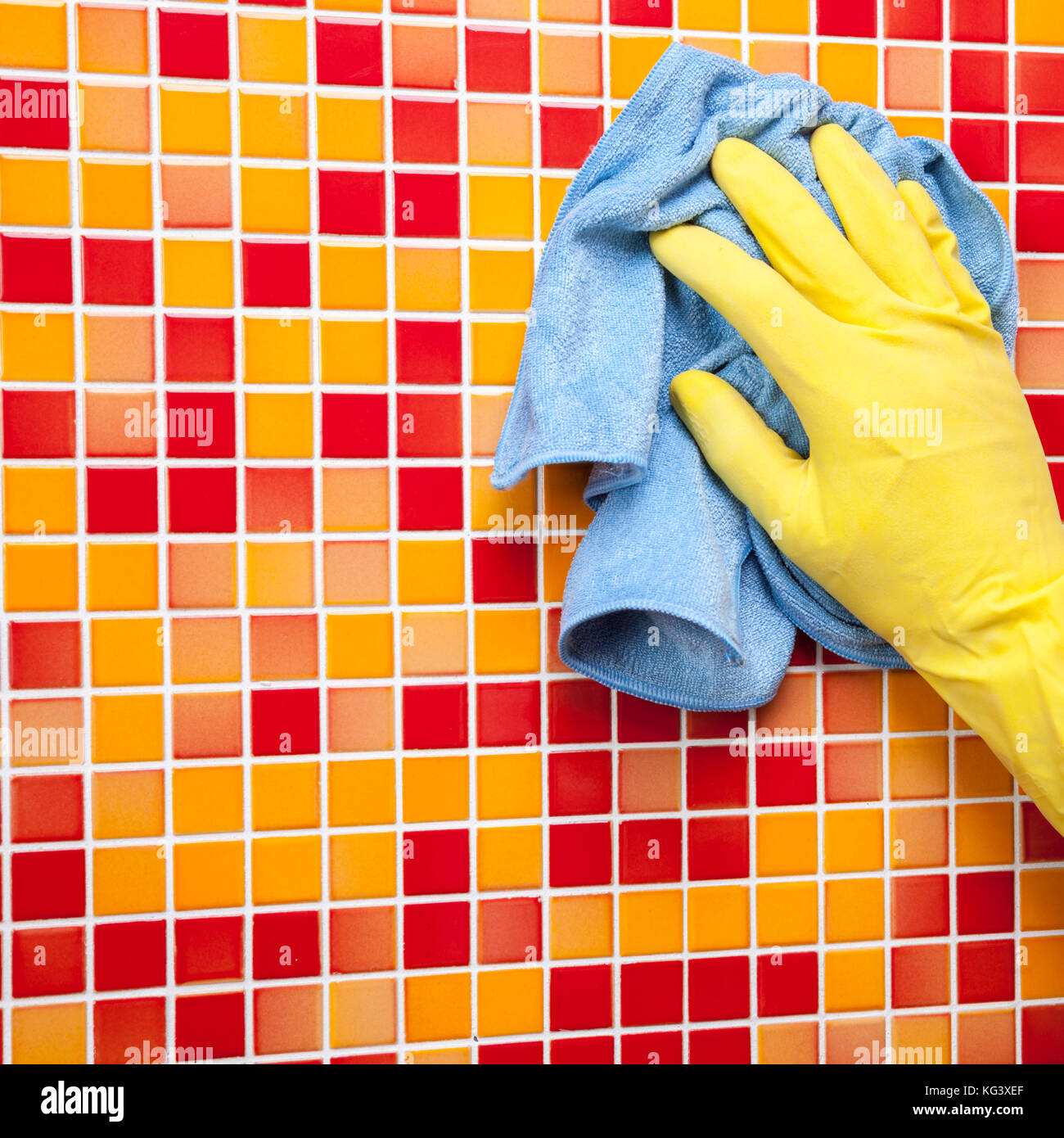 Person, Aufgaben im Bad zu Hause reinigen Fliesen- wand mit Mikrofasertuch Stockfoto