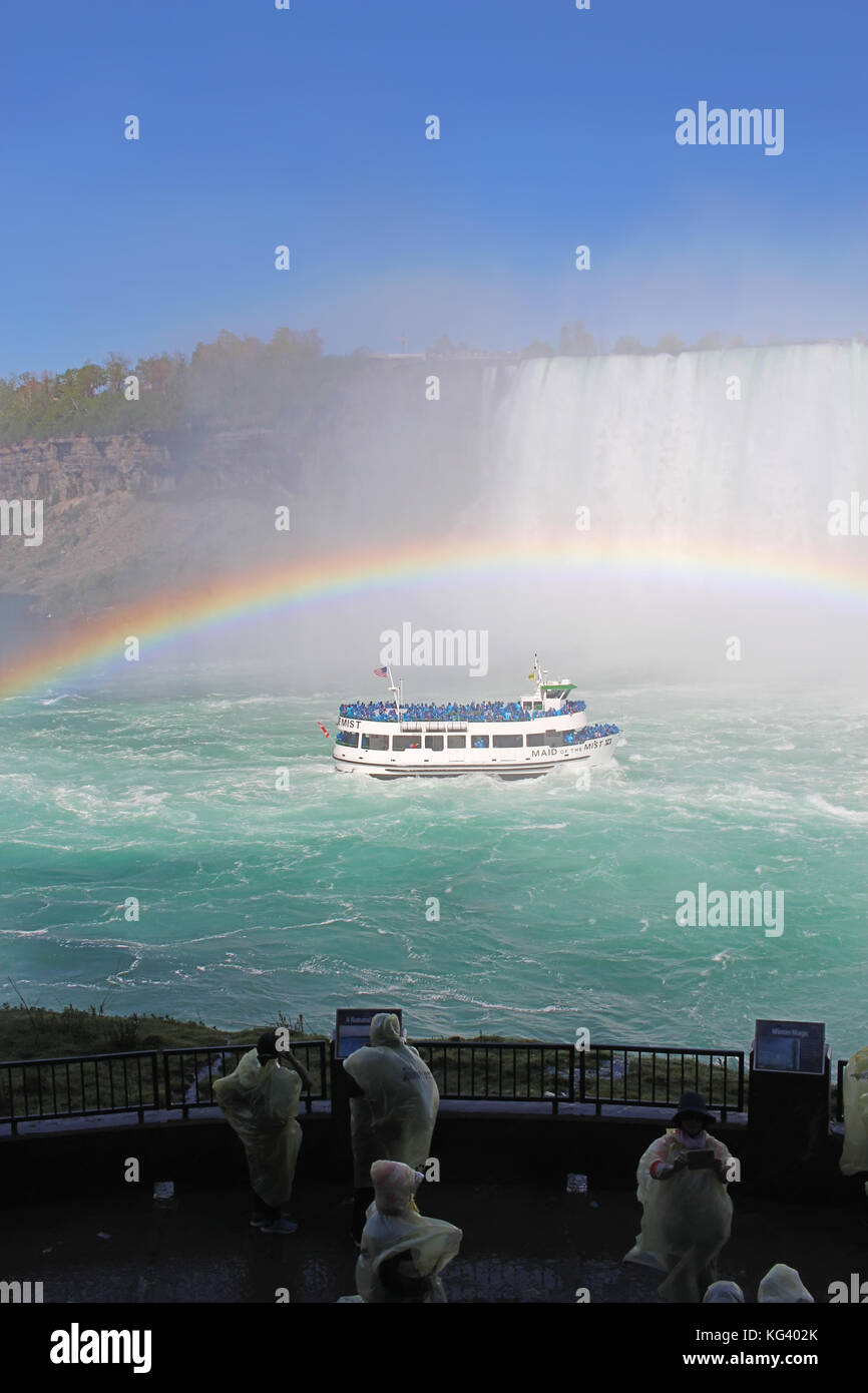 Niagara Falls, Kanada - 29. Mai 2017: Touristen zusehen, wie die Mädchen des Nebels tour Boot nähert sich dem tobenden Katarakte von Horseshoe Falls unter einer kompl Stockfoto