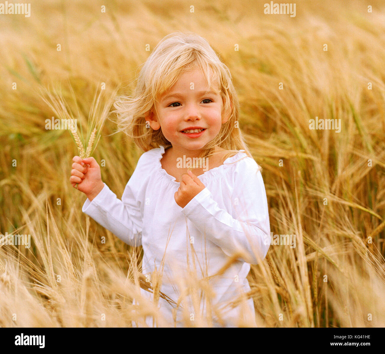 Kinder. Kleine blonde Mädchen draußen im Feld. Stockfoto