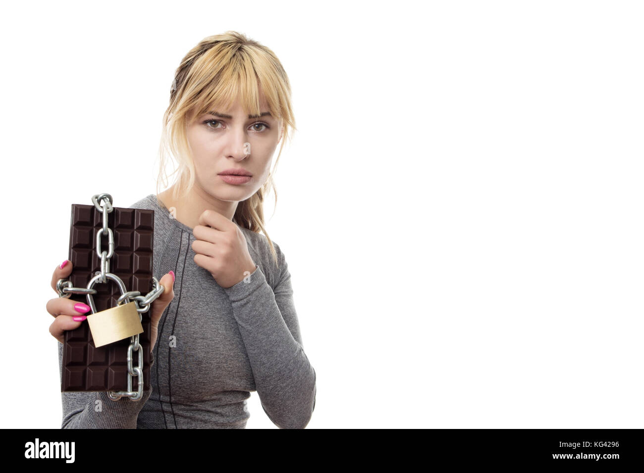 Fitness Frau mit einem Schokoriegel in Ketten gesichert Stockfoto