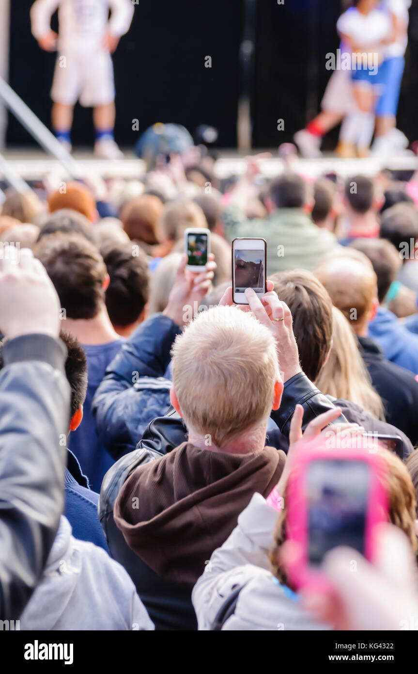 Viele Leute bei einem Konzert im freien Benutzung von Mobiltelefonen, Fotos oder Videos aufnehmen Stockfoto