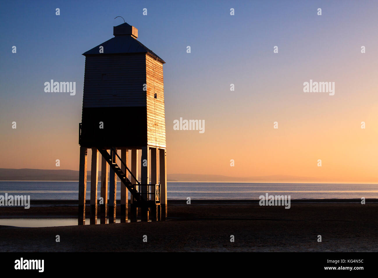 Burnham-on-Sea, Holz-, Leuchtturm durch die untergehende Sonne beleuchtet auf einer klaren Sommer Abend. Stockfoto