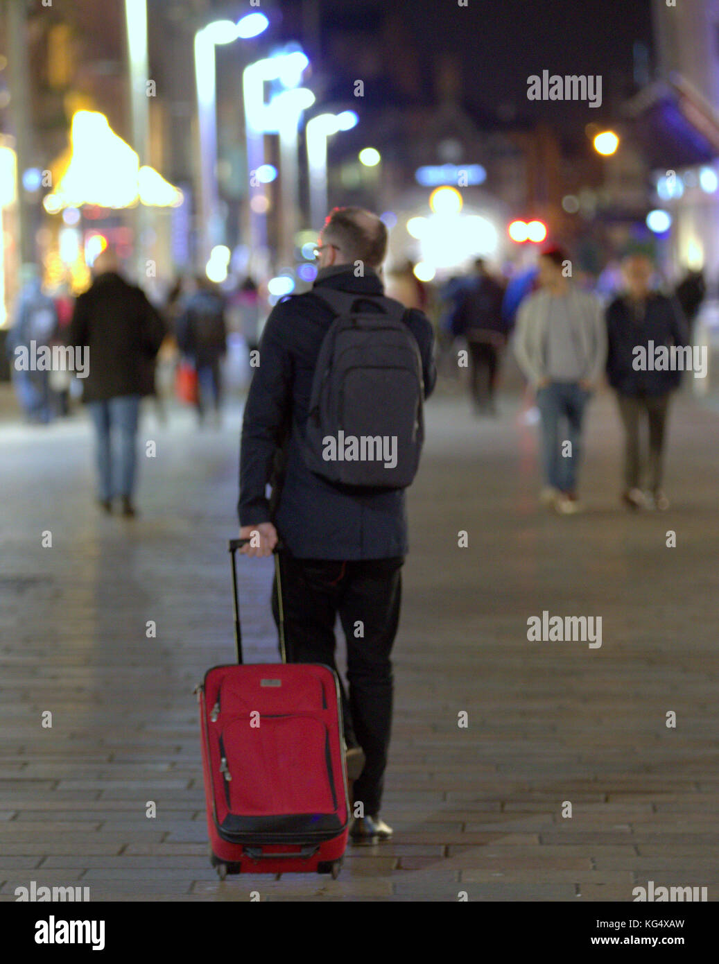 Touristen Geschäftsmann auf der belebten Straße mit Trolleys Taschen warten auf Taxi uber Fahrt auf dem Smartphone mobile gesehen von hinten Stockfoto