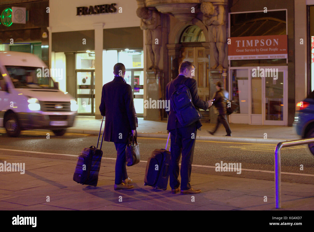 Touristen Geschäftsmann auf der belebten Straße mit Trolleys Taschen warten auf Taxi uber Fahrt auf dem Smartphone mobile gesehen von hinten Stockfoto
