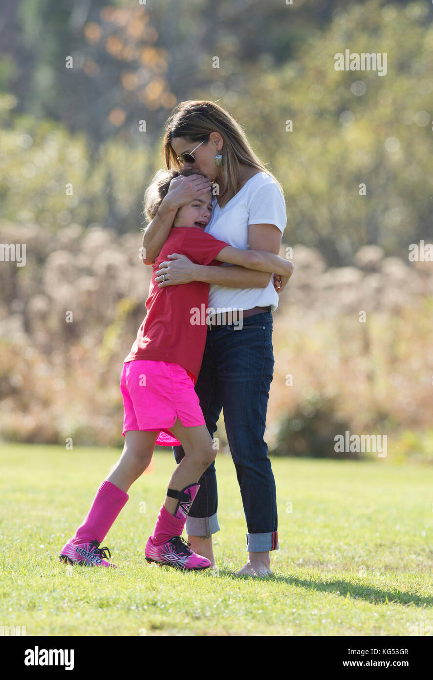 Ein 6 Jahre altes Mädchen spielen in einem Fußballspiel von ihrer Mutter getröstet folgenden verletzt. Waterbury, Vermont, USA Stockfoto