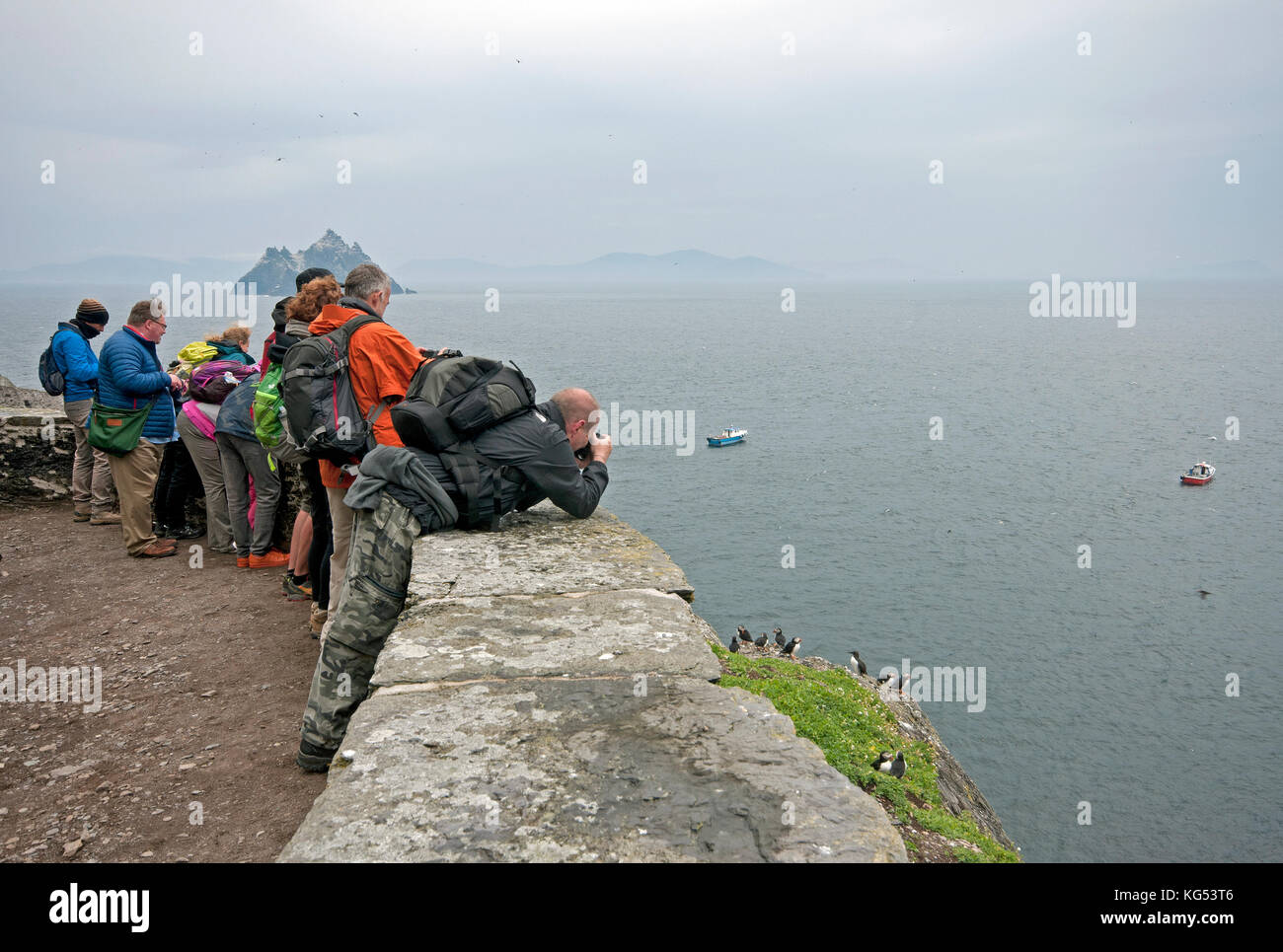 Touristen fotografieren Papageitaucher (Fratercula arctica) auf Skellig Michael Insel, County Kerry, Irland Stockfoto