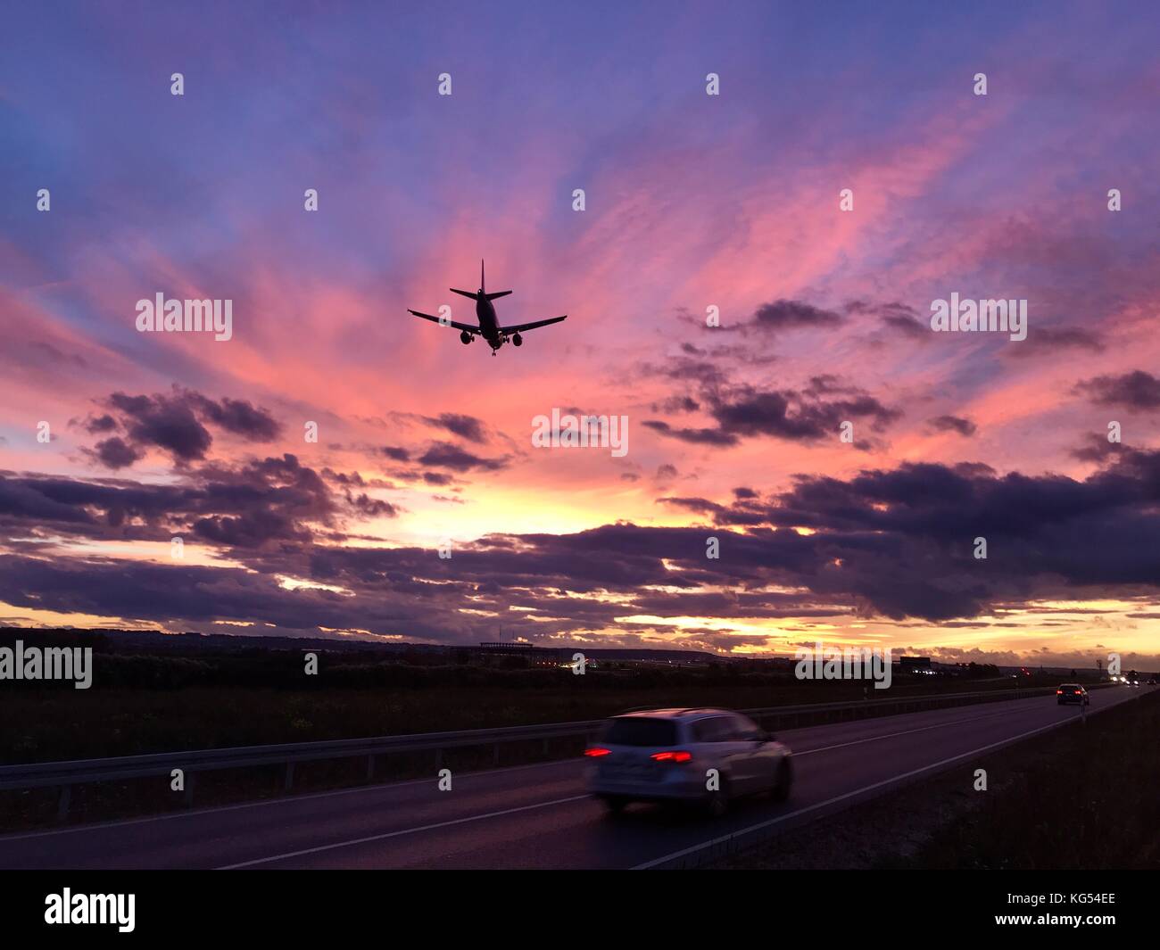 Ein Flugzeug nähert sich der Flughafen Stuttgart in einer dramatischen Sonnenuntergang Stockfoto