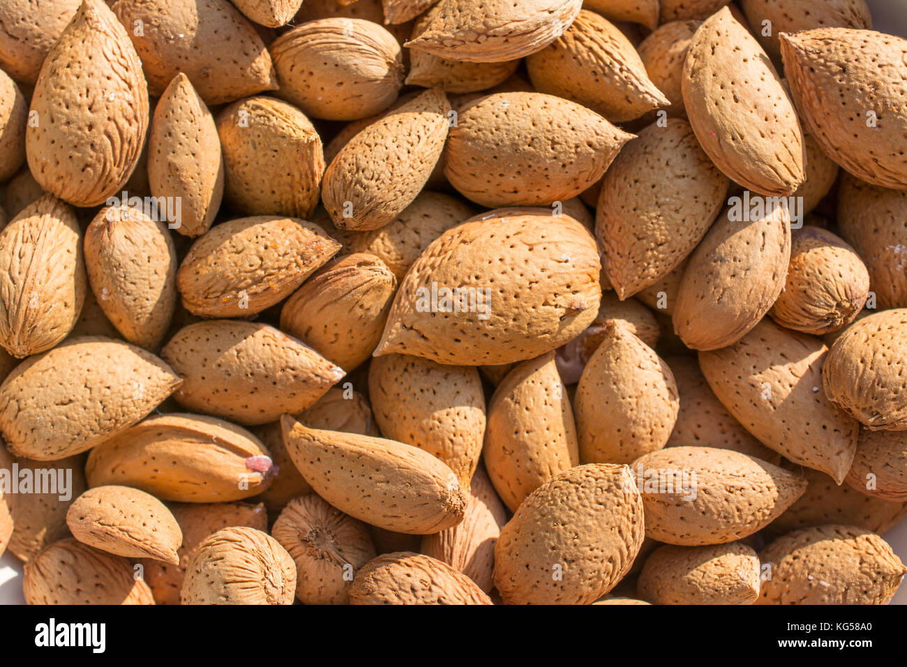 Gruppe von rohen Mandeln mit Haut und Rinde, Hintergrund. Hauptbestandteil für Nougat sizilianischen Stockfoto