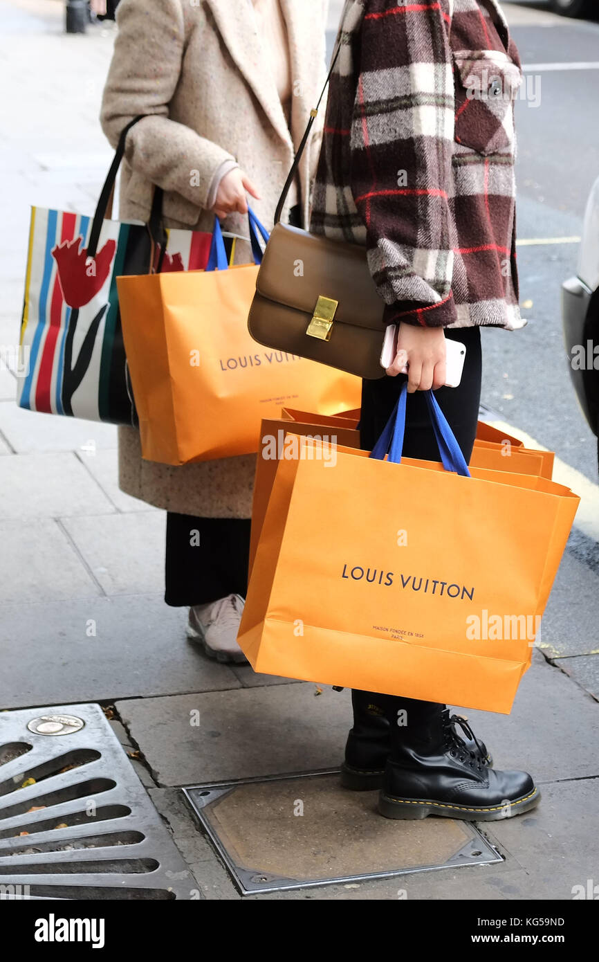 Designer Shopping auf der Oxford Street, dem Käufer ein Taxi anhalten, nachdem ich Tausende von Pfund/Dollar/Yen etc. bei Louis Vuitton in Selfridges in London. Stockfoto