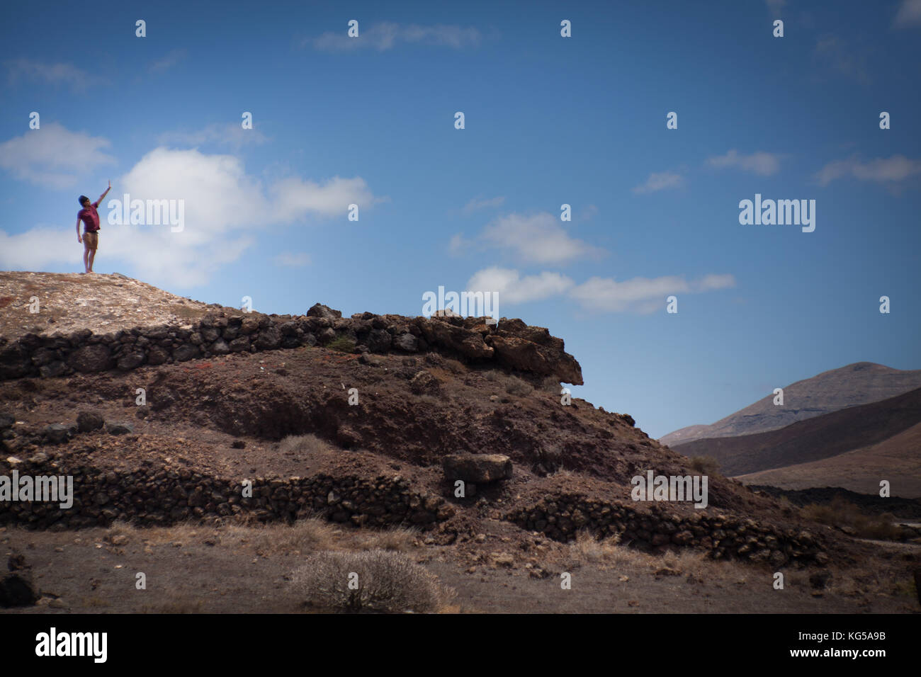 Mann stehend auf einem Höchststand, Träume und Wolken berühren. Stockfoto