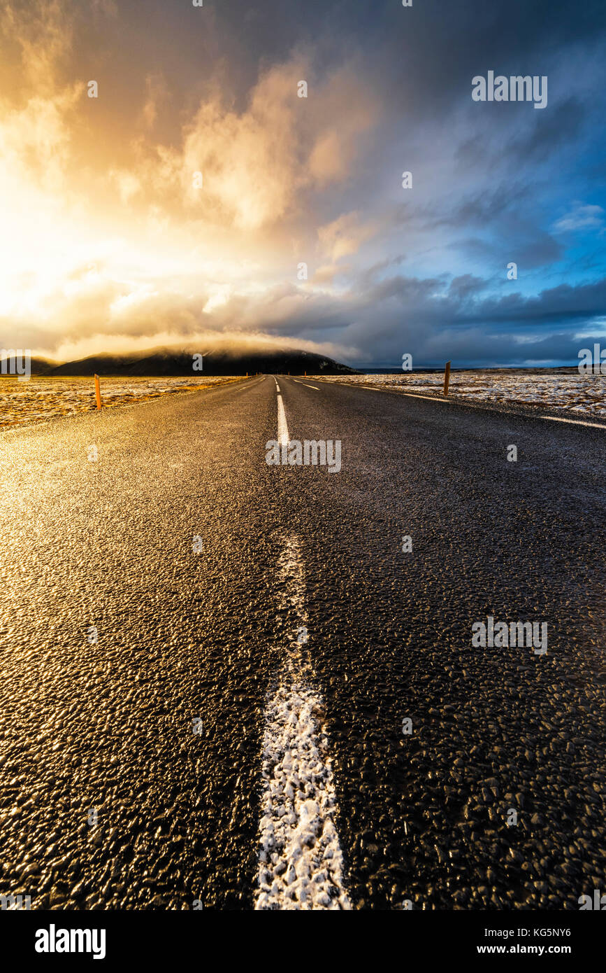 Island, Nordeuropa. Eine gepflasterte Straße mit dramatischen Himmel Stockfoto