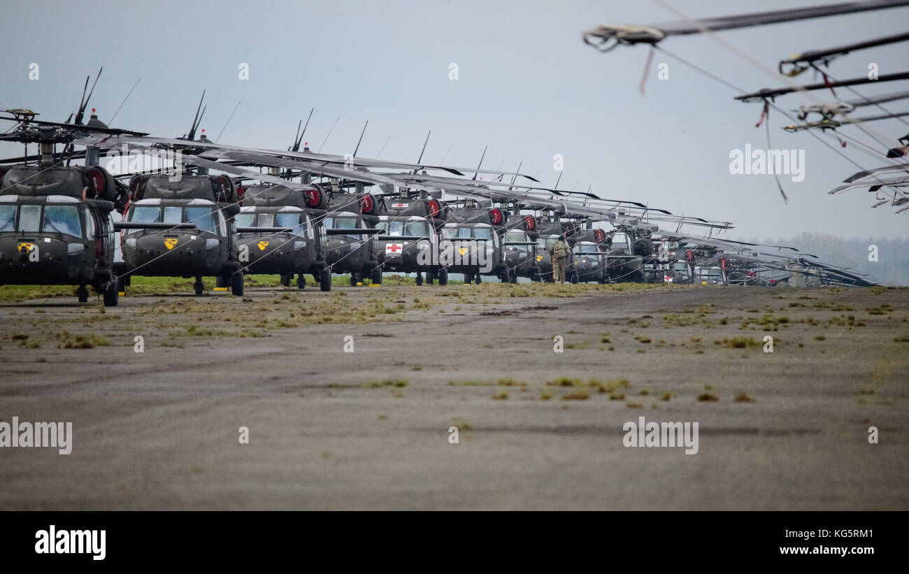 Ein US-Soldat mit 1 Air Cavalry Brigade, 1.Kavallerie Division, bringt Ausrüstung zu einem der 77 Hubschraubern auf chièvres Air Base, Belgien inszeniert, Stockfoto