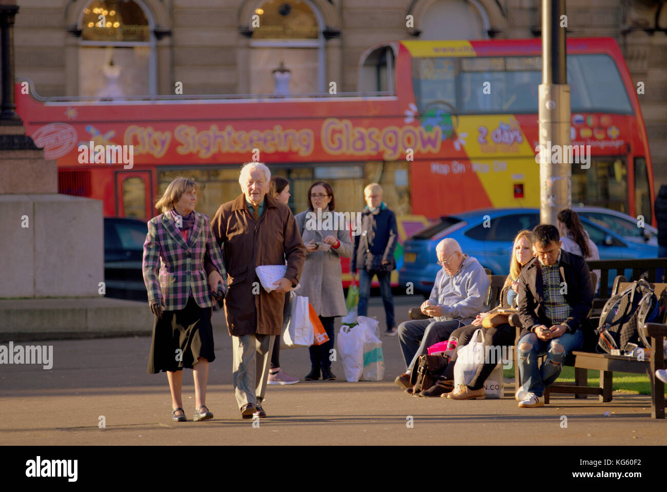 City Sightseeing gesunde Senioren Paar Mann und Frau Touristen an einem sonnigen Tag den George Square, Glasgow, Glasgow, Vereinigtes Königreich Stockfoto
