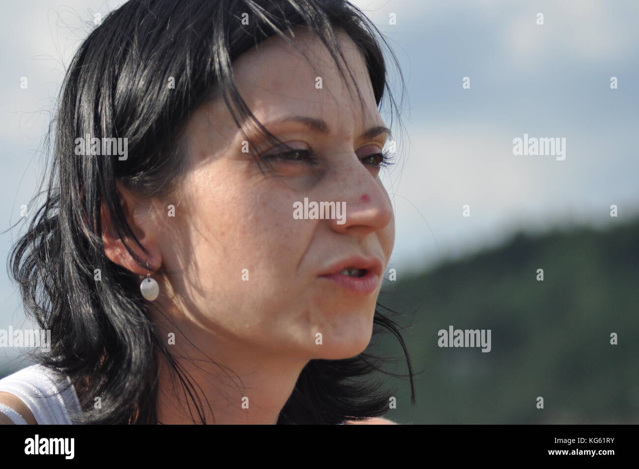 Die Frau unterhalten und nachdenklich. Mädchen mit Ohrringe. Lächeln und Zufriedenheit. Stockfoto