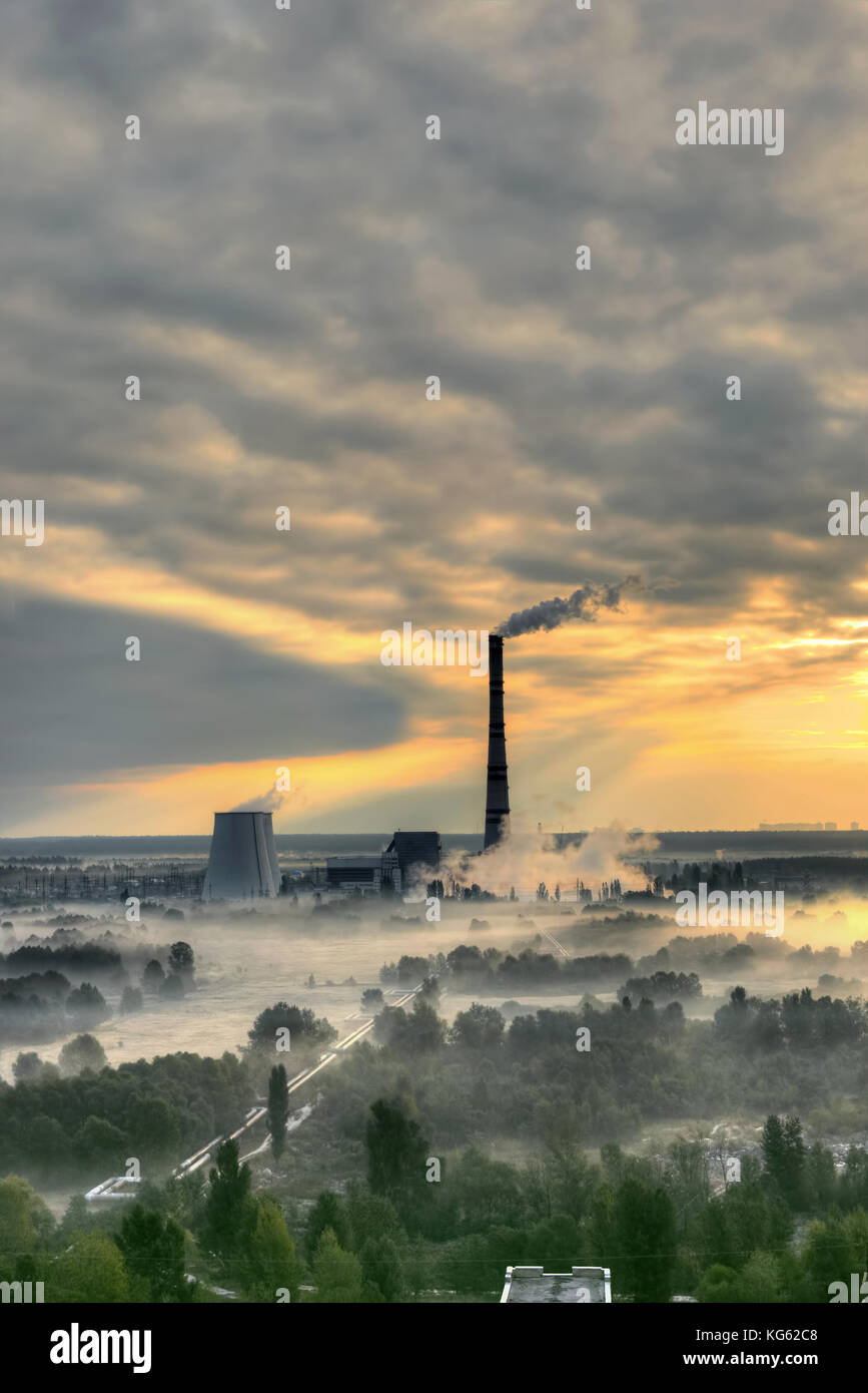 Sonnenaufgang über dem Kraftwerk mit Nebel im Tal Stockfoto