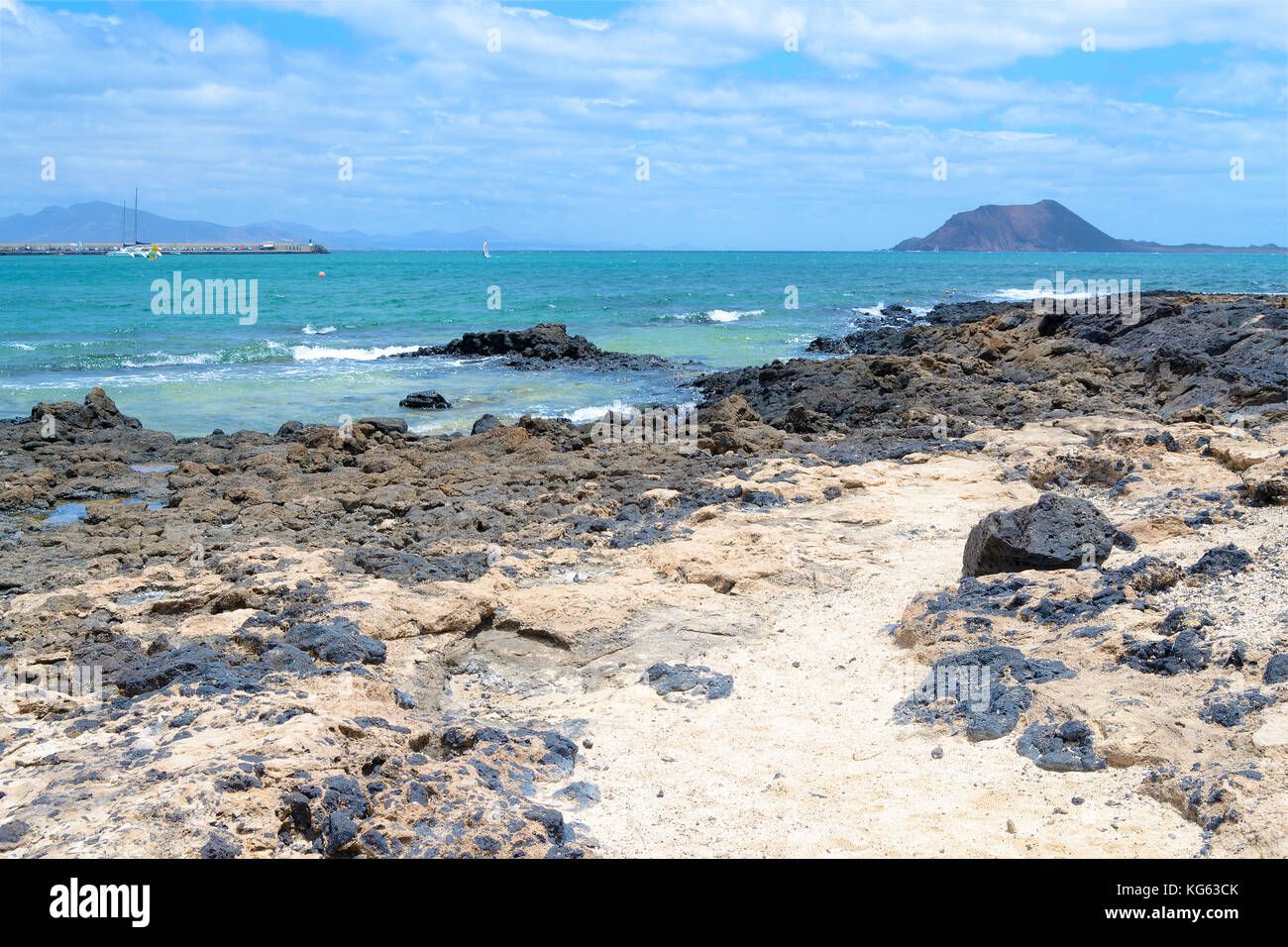 Weißer Strand mit schwarzen vulkanischen Felsen, am Meer, Corralejo, Fuerteventura, Kanarische Inseln, Spanien Stockfoto