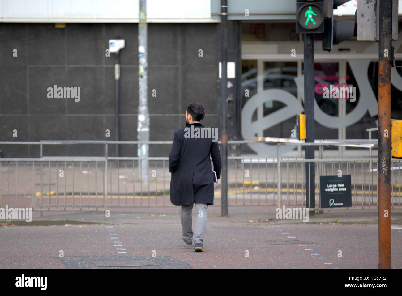Junge stilvollen Mann Kreuzung Straße an der Ampel mit grünen Mann gesehen von hinten Stockfoto