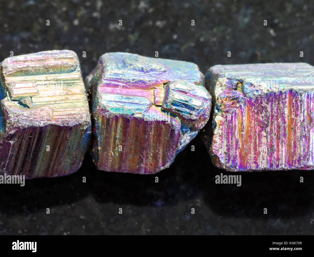 Makroaufnahmen von natürlichen Mineralgestein Muster - Perlen aus irisierendem Pyrit Edelstein auf dunklem Granit Hintergrund Stockfoto
