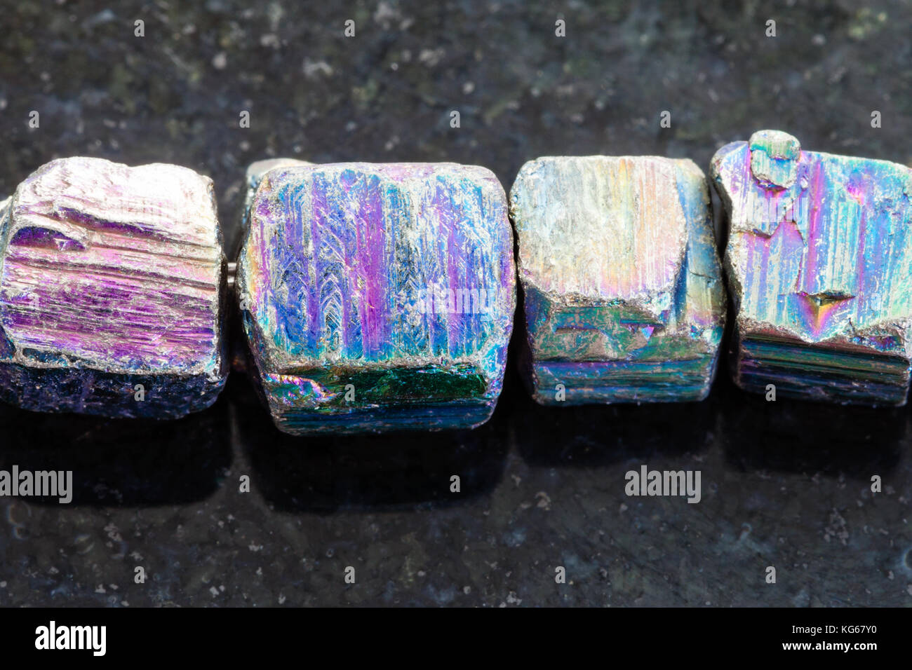 Makroaufnahmen von natürlichen Mineralgestein Muster - Halskette aus irisierendem Pyrit Edelstein auf dunklem Granit Hintergrund Stockfoto