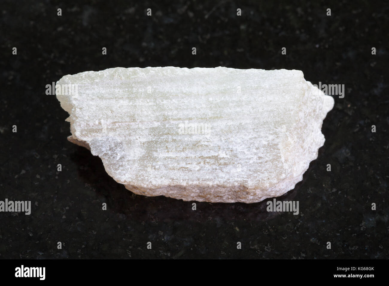 Makroaufnahmen von natürlichen Mineralgestein Muster - raw Talkum Stein auf dunklem Granit Hintergrund Stockfoto