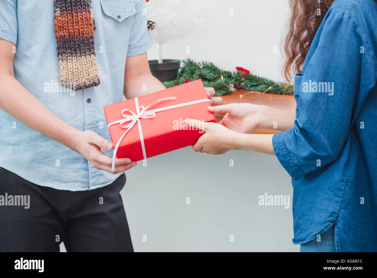 Geschenke für Weihnachten und das neue Jahr, Nahaufnahme, Mann, Hand rot vorhanden, um die Frau zu Xmas Party, Urlaub feier Konzept. Stockfoto