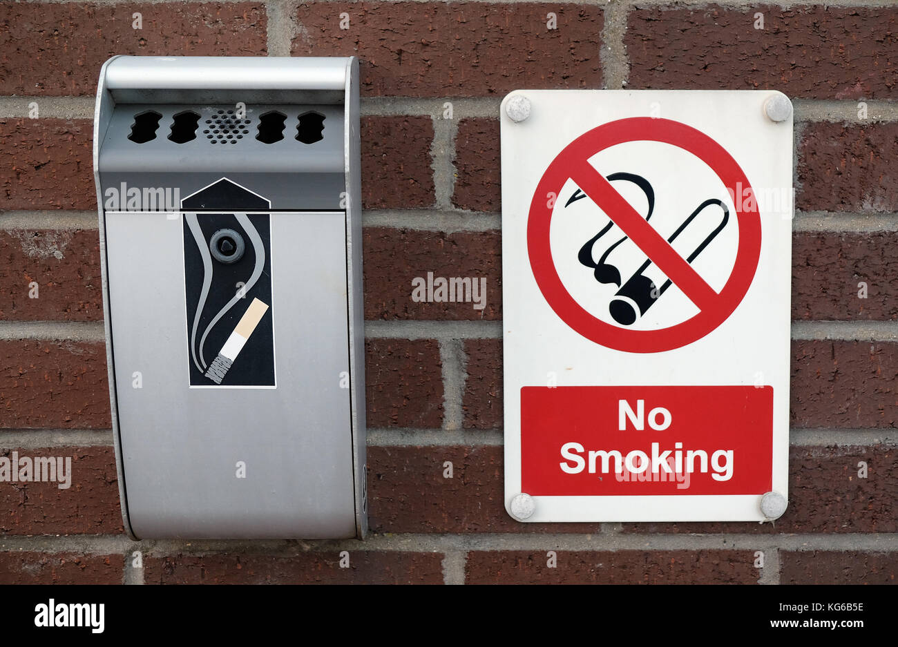 No Smoking Sign und Abfall Zigarettenschachtel auf Wand außerhalb des Gebäudes mit UK Recht zu entsprechen. Stockfoto