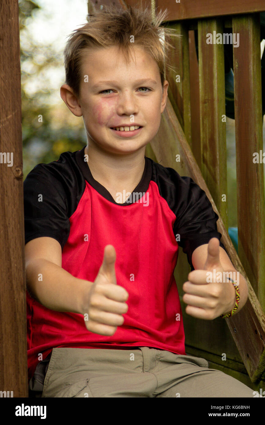 Pre-teen Boy geben ok Geste Sitzen Stockfoto