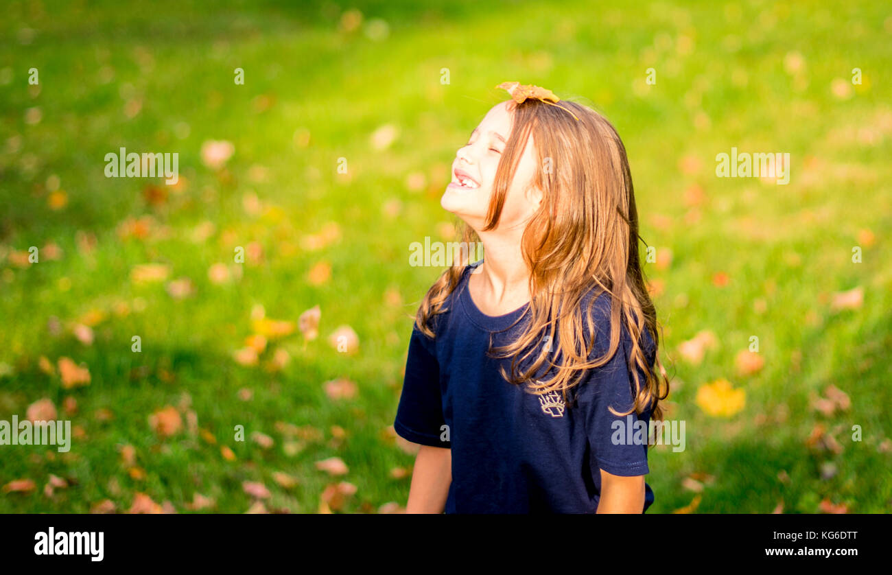 Mädchen spielen mit Herbstlaub Stockfoto