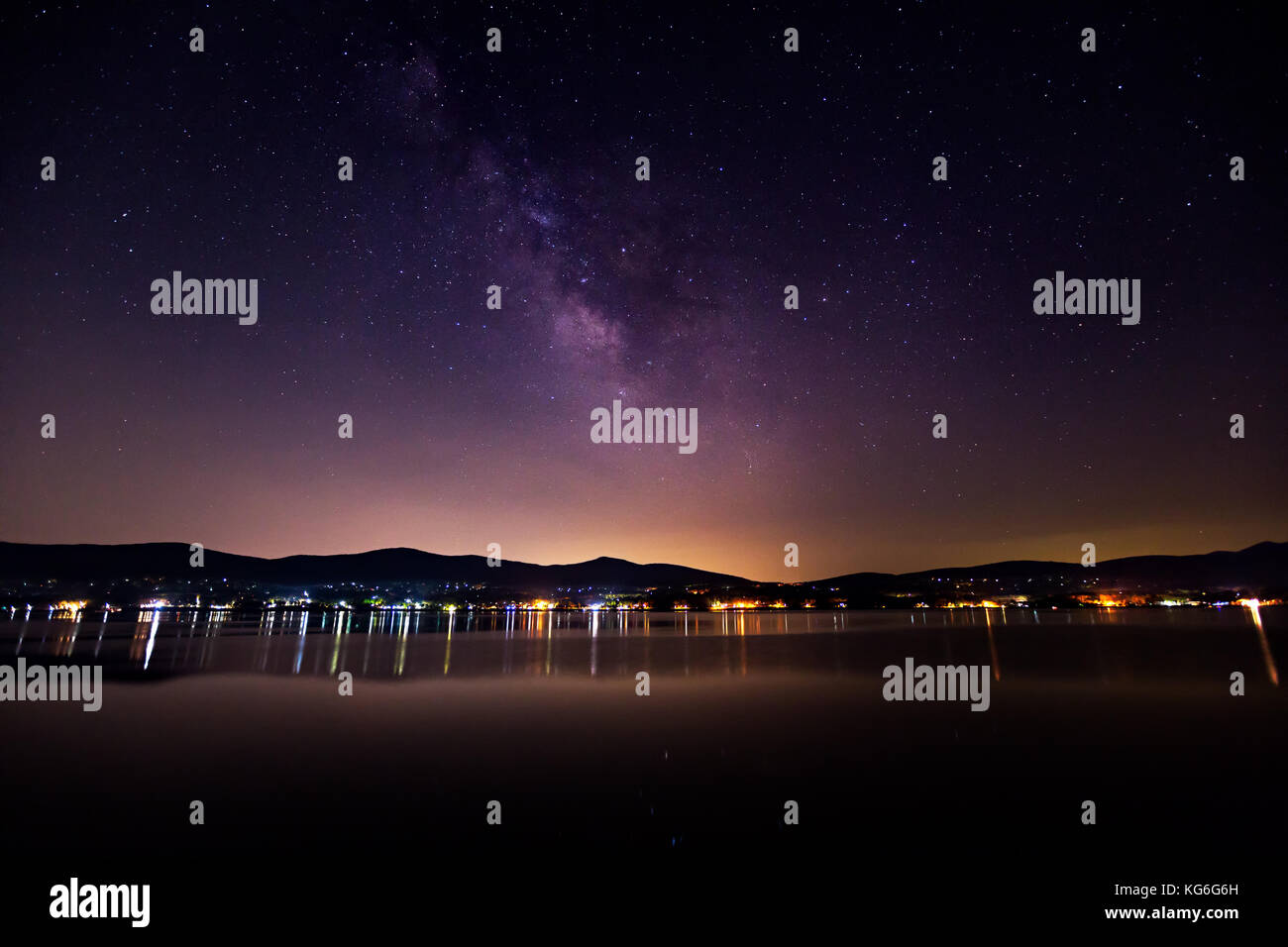 Die Milchstraße über den See kawaguchiko in einer klaren Nacht mit der Stadt leuchten Stockfoto