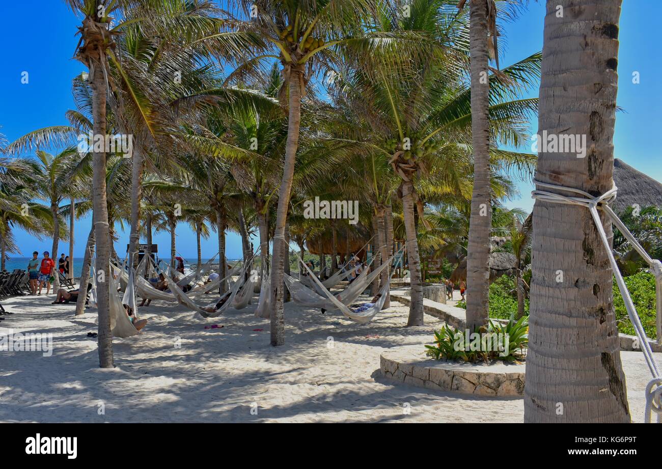 XCARET, Mexiko - 1. Juli 2017: Menschen, die sich in Hängematten am Sandstrand entspannen. Stockfoto
