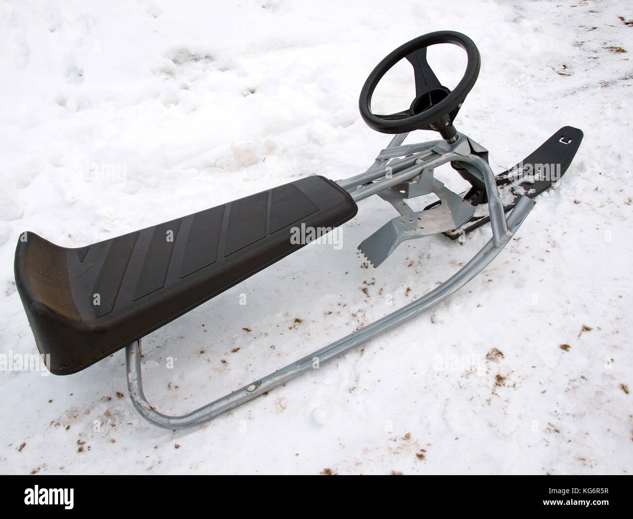 Schlitten mit weichen Sitz und Lenkrad auf Schnee Stockfotografie